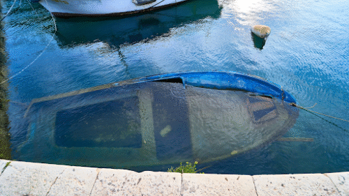 boating accident scene with people on a damaged boat in open water